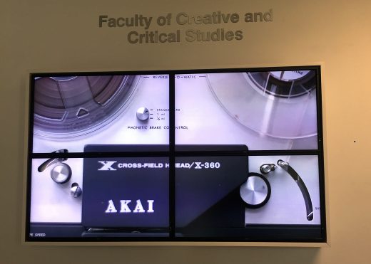 a video screen featuring a clip of a reel-to-reel machine turning