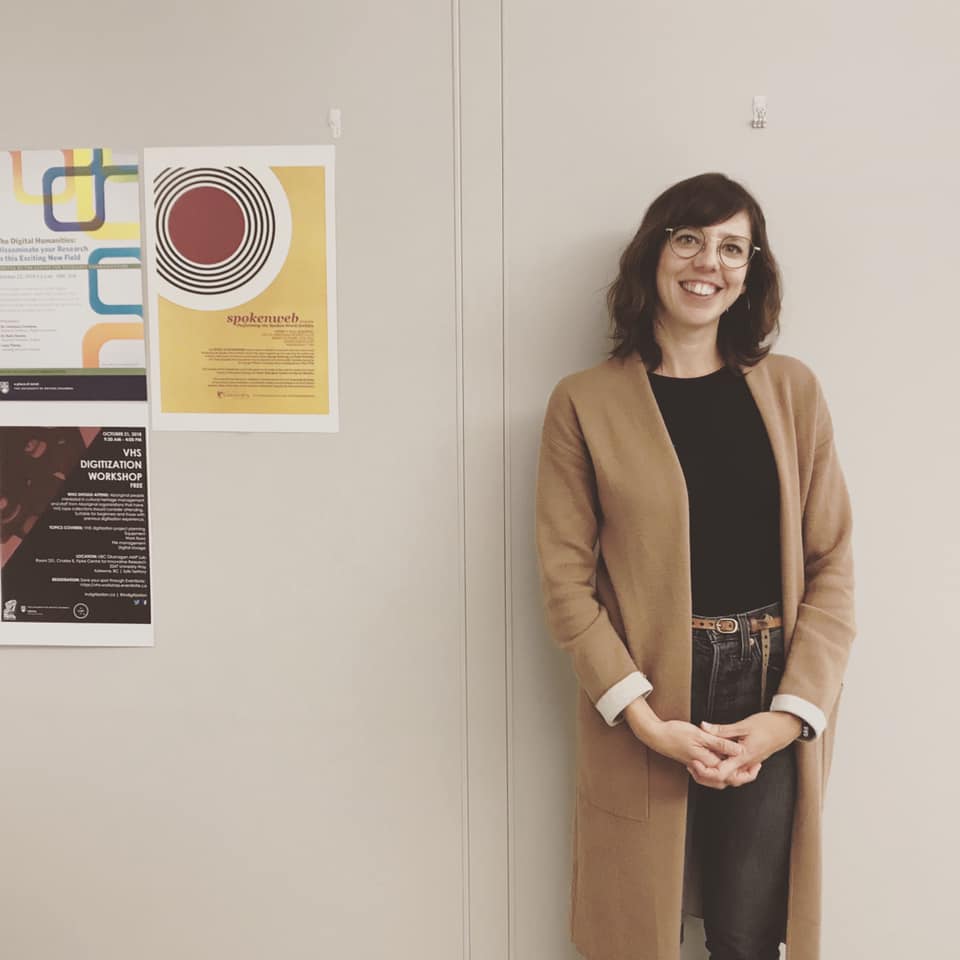 Carrie Karsgaard standing against a wall with posters