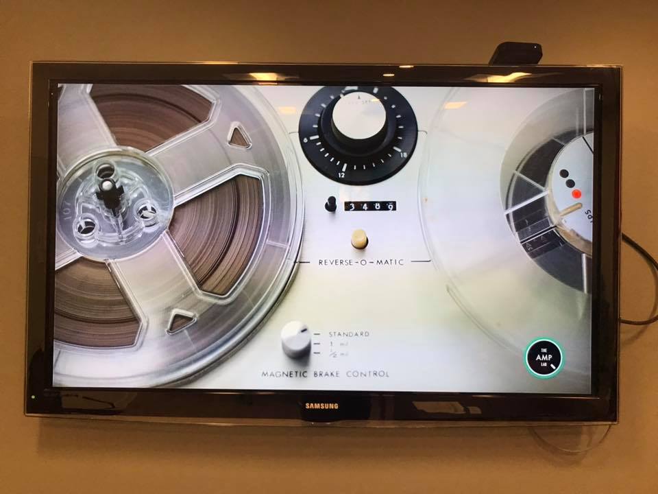 A screen shows a video clip of a reel-to-reel machine playing a tape